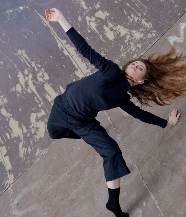 Woman performing a fluid cardio movement in a calm, focused environment.